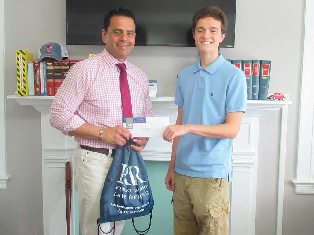 Photo of attorney Russo handing a scholarship check to student